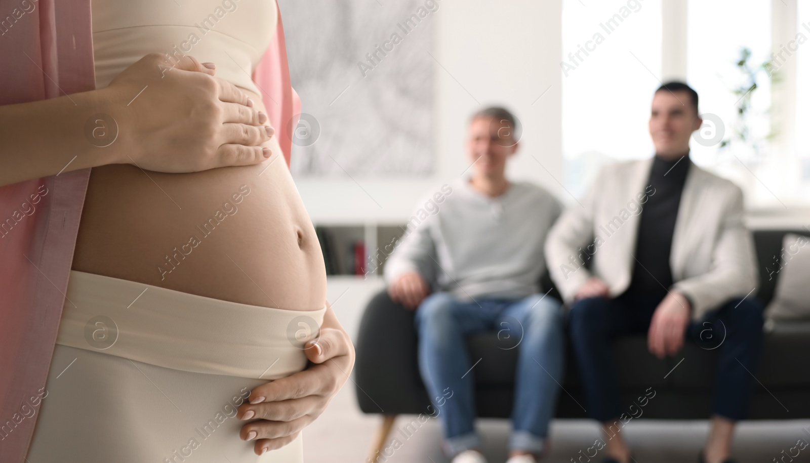 Image of Pregnant surrogate mother and happy gay couple at home, selective focus