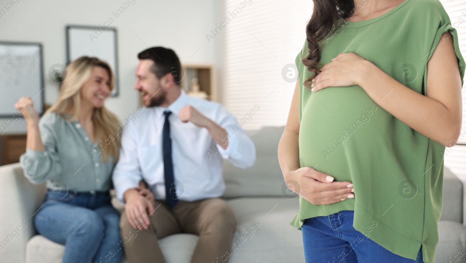 Image of Pregnant surrogate mother and happy couple at home, selective focus