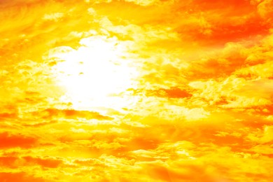 Image of Orange sky with sun and clouds during hot summer weather