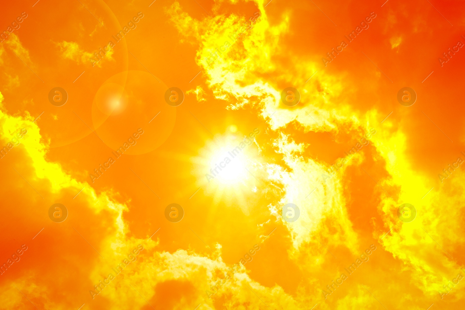 Image of Orange sky with sun and clouds during hot summer weather