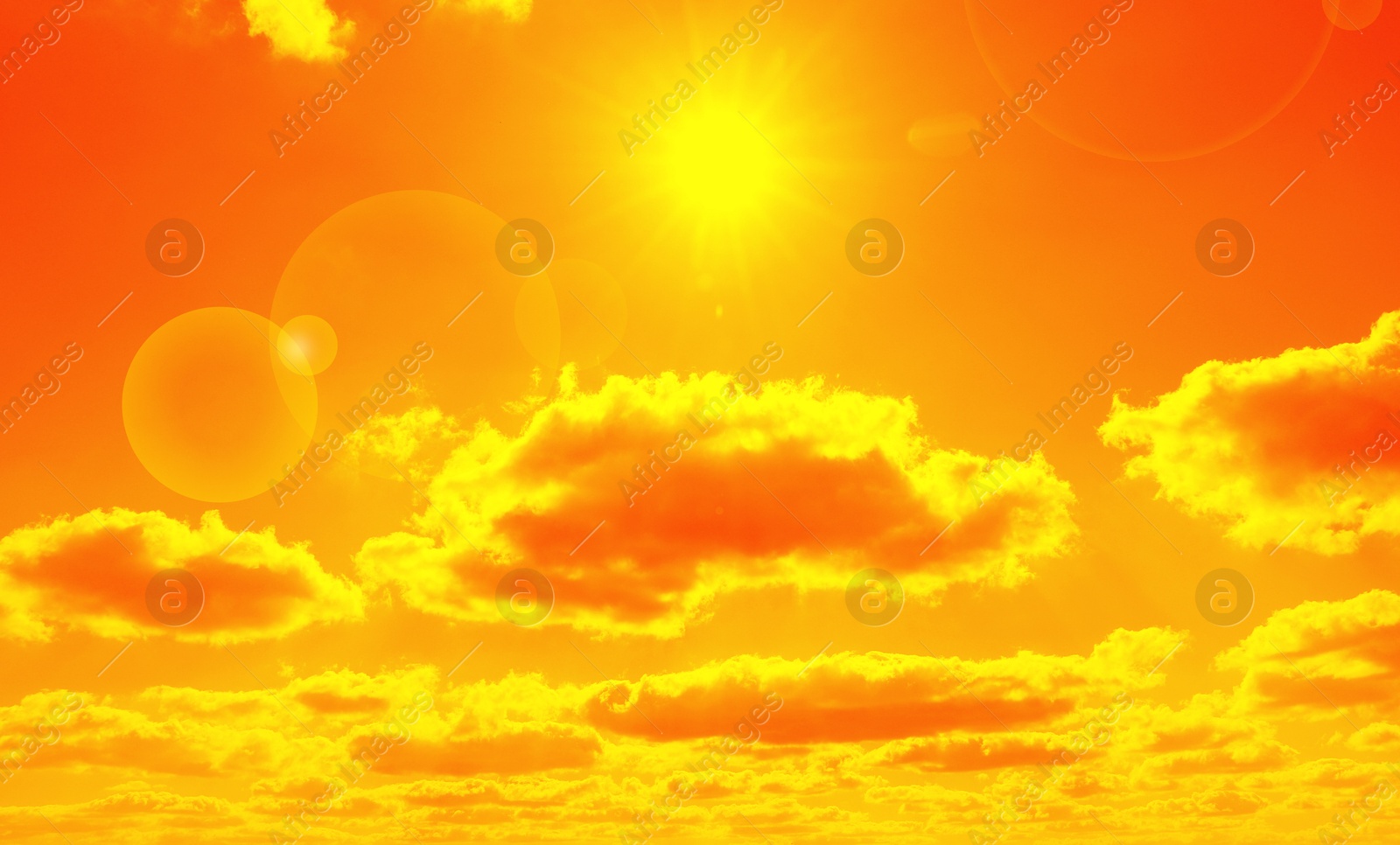 Image of Orange sky with sun and clouds during hot summer weather