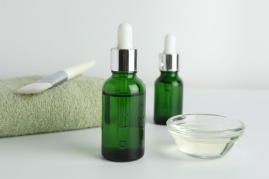 Bottles of chemical peel, bowl with liquid, towel and brush on light background, closeup. Peeling procedure