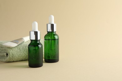 Photo of Bottles of chemical peel, towel and brush on beige background, space for text. Peeling procedure