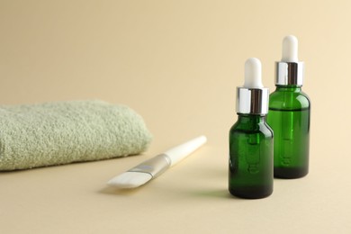 Bottles of chemical peel, towel and brush on beige background. Peeling procedure