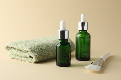 Bottles of chemical peel, towel and brush on beige background. Peeling procedure