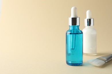 Photo of Bottles of chemical peel and brush on beige background, space for text. Peeling procedure