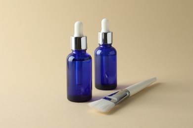 Bottles of chemical peel and brush on beige background. Peeling procedure