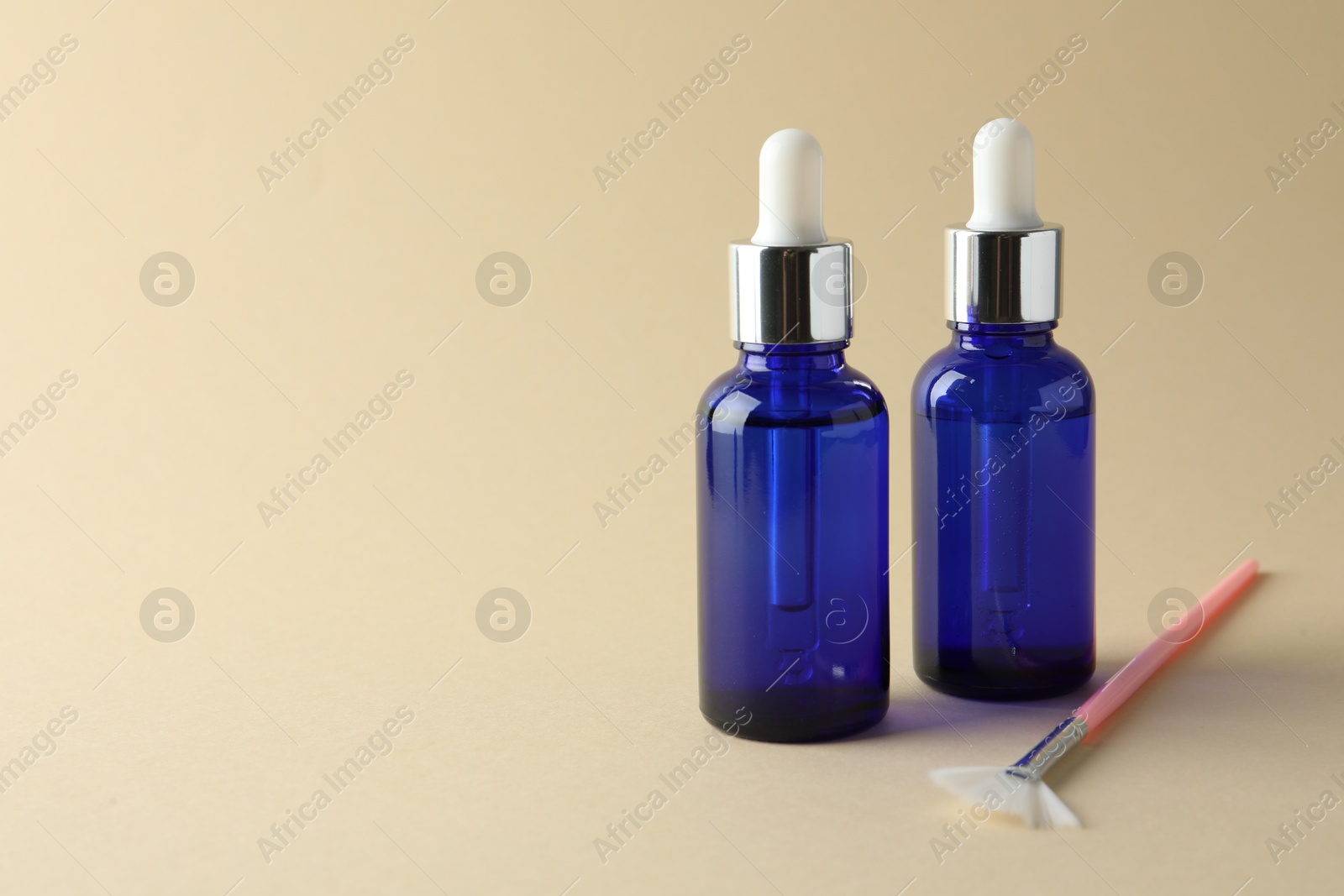 Photo of Bottles of chemical peel and brush on beige background, space for text. Peeling procedure