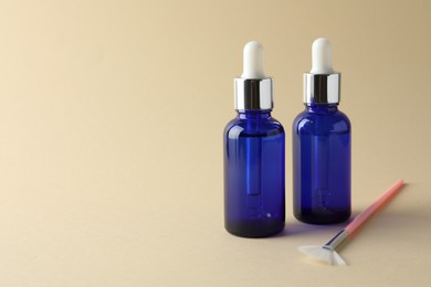 Bottles of chemical peel and brush on beige background, space for text. Peeling procedure