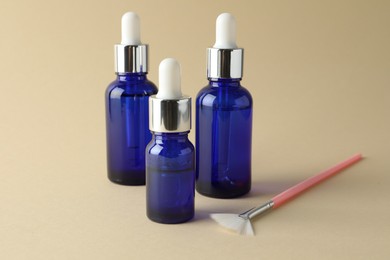 Bottles of chemical peel and brush on beige background. Peeling procedure