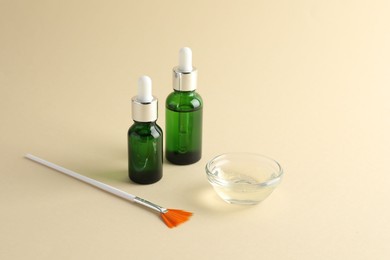 Bottles of chemical peel, bowl with liquid and brush on beige background. Peeling procedure