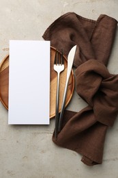 Empty menu, plate, cutlery and napkin on light grey table, top view. Mockup for design