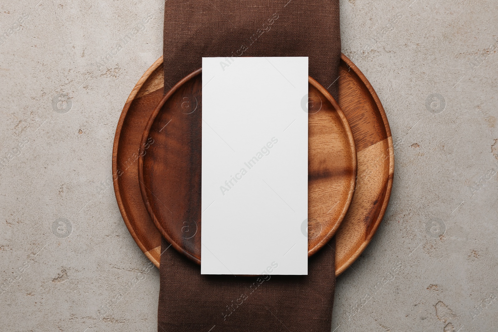 Photo of Empty menu and plates on light grey table, top view. Mockup for design