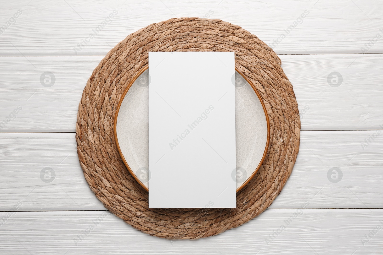 Photo of Empty menu and plate on white wooden table, top view. Mockup for design