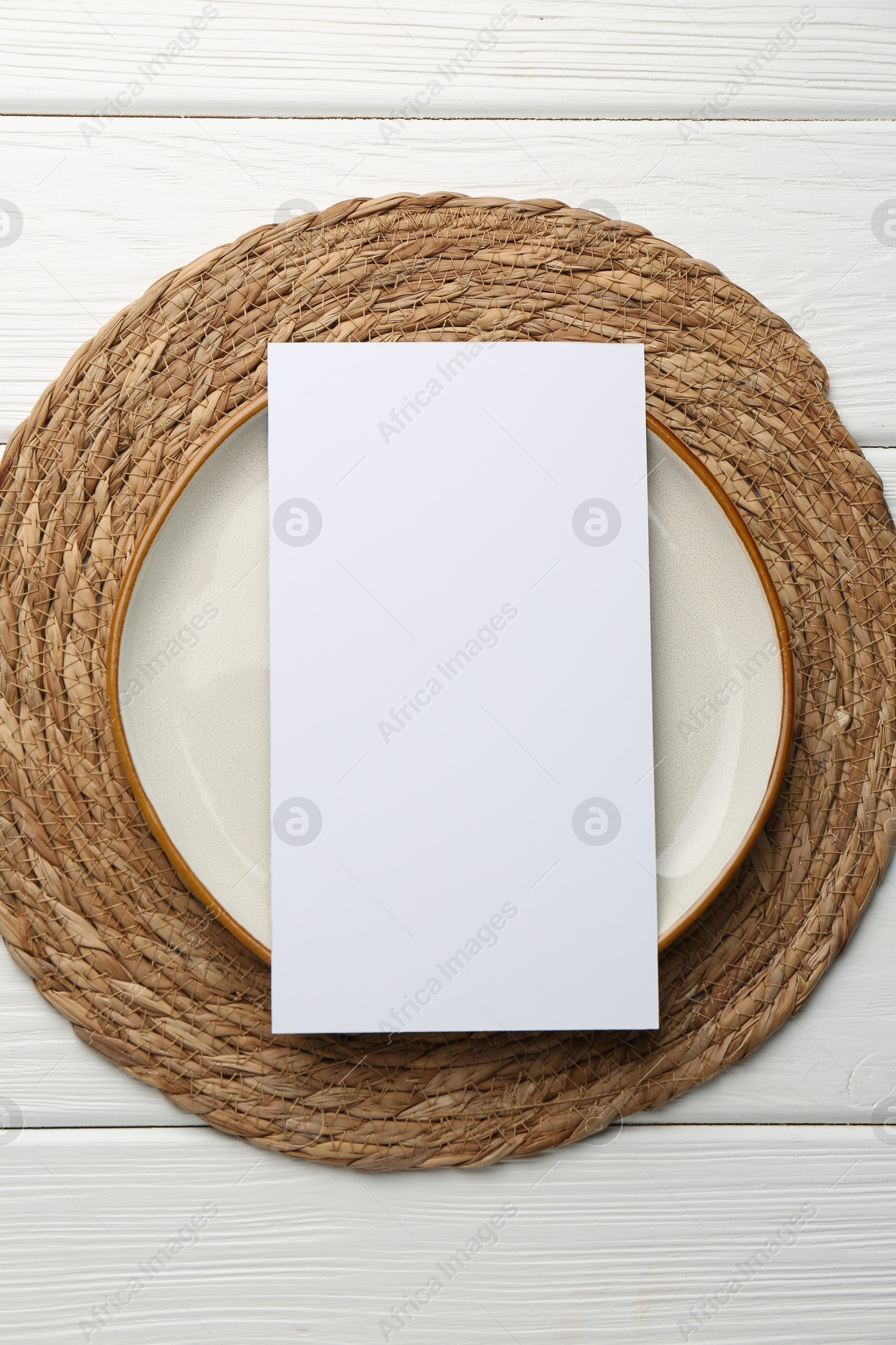 Photo of Empty menu and plate on white wooden table, top view. Mockup for design