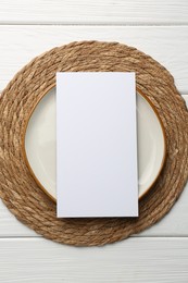 Photo of Empty menu and plate on white wooden table, top view. Mockup for design