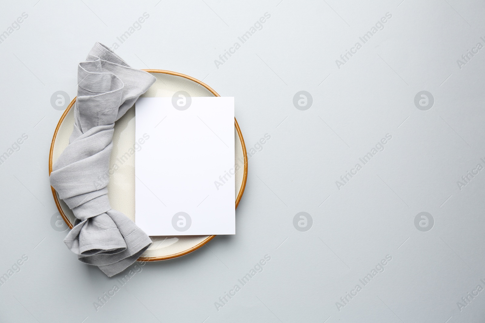 Photo of Empty menu, plate and napkin on light grey background, top view. Mockup for design