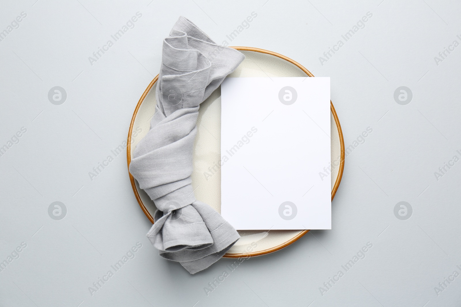 Photo of Empty menu, plate and napkin on light grey background, top view. Mockup for design