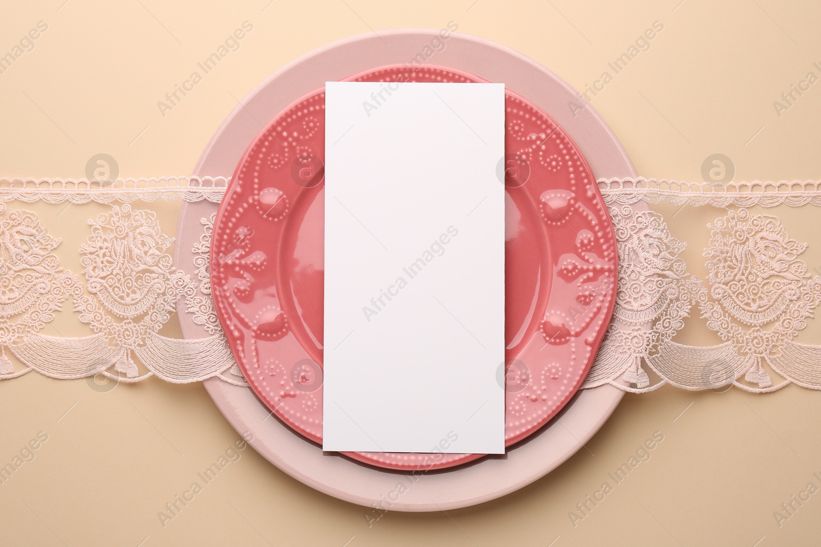 Photo of Empty menu and plates on beige background, top view. Mockup for design