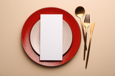 Photo of Empty menu, plates and cutlery on beige background, top view. Mockup for design