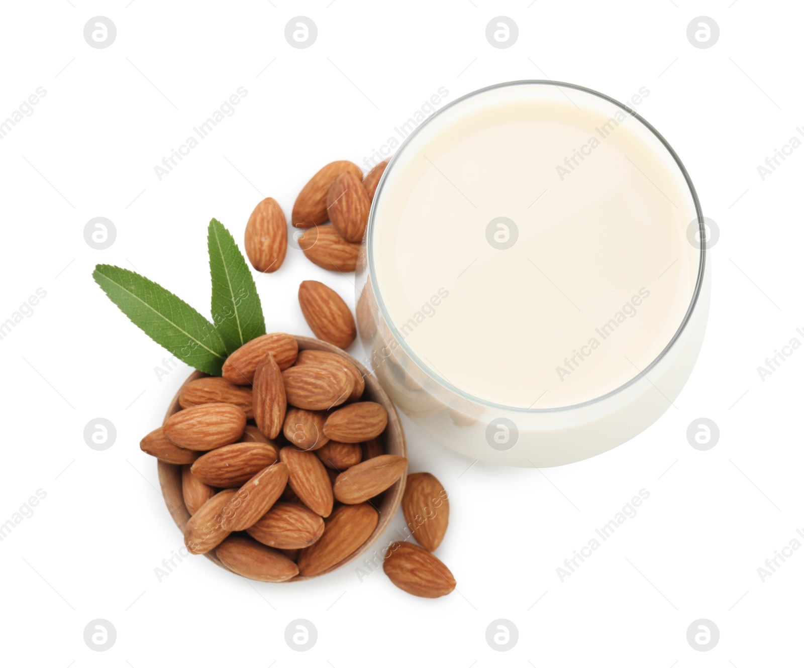 Photo of Glass of almond milk and almonds isolated on white, top view