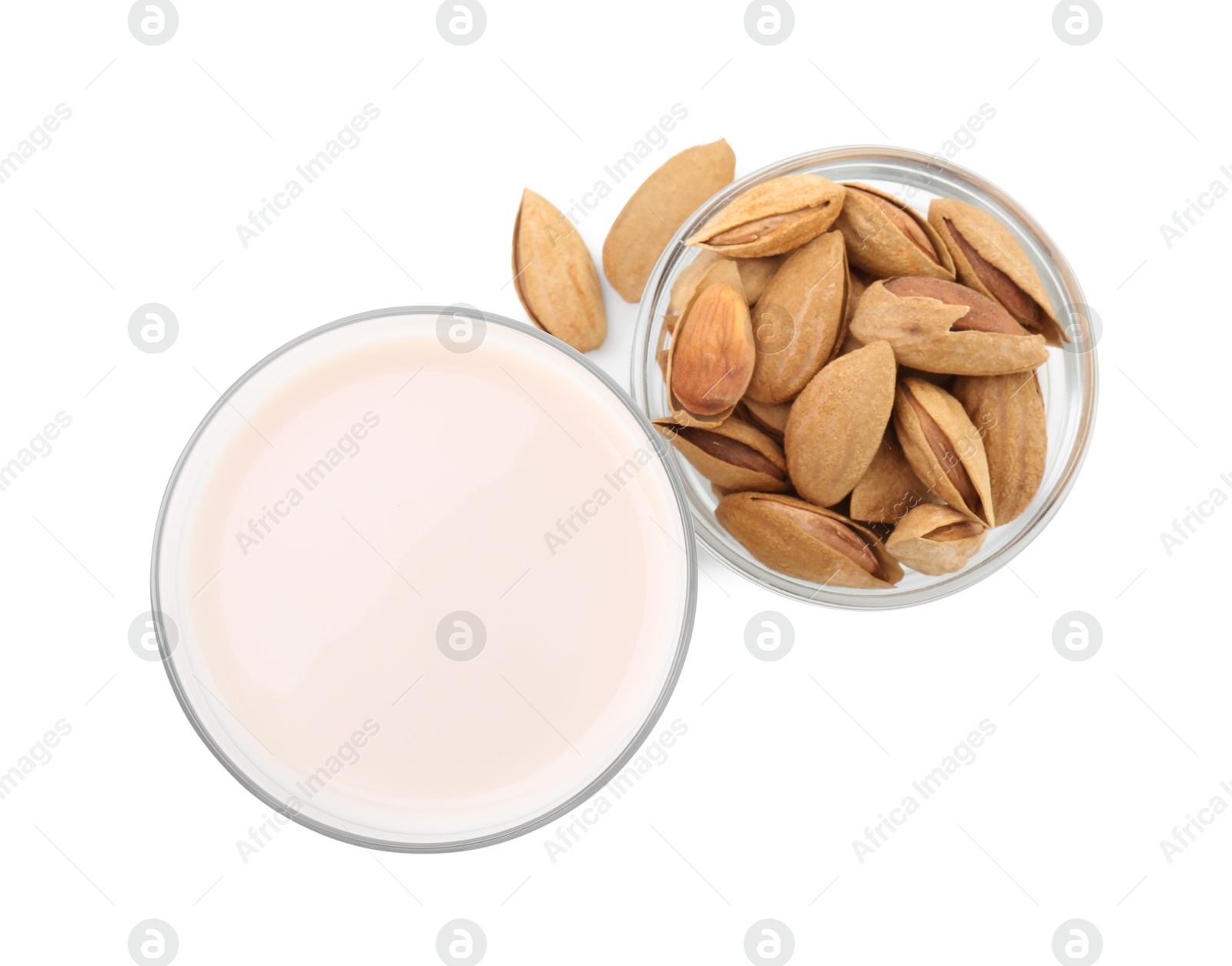 Photo of Glass of almond milk and almonds isolated on white, top view