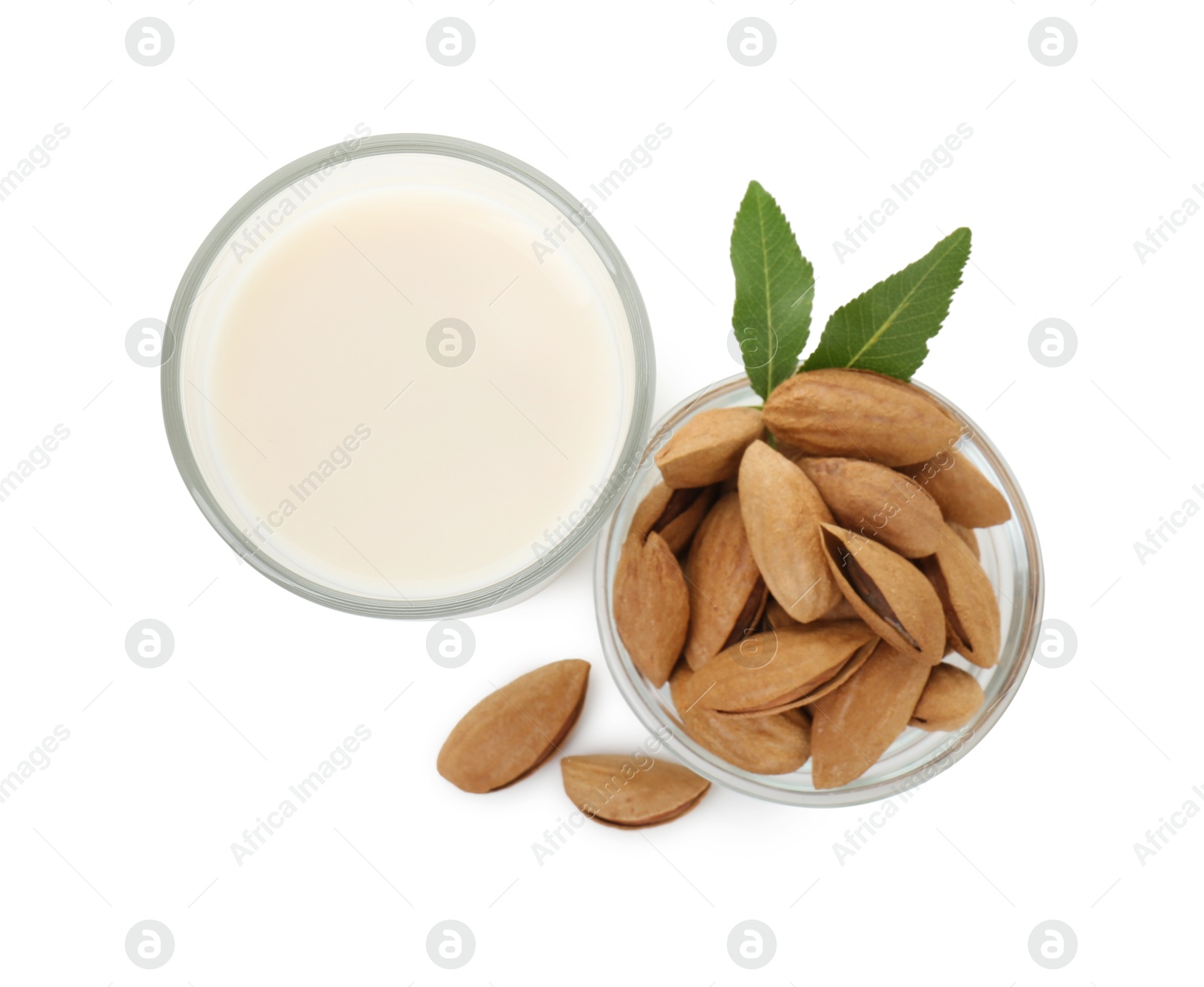 Photo of Glass of almond milk and almonds isolated on white, top view