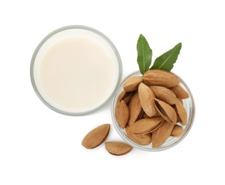 Glass of almond milk and almonds isolated on white, top view