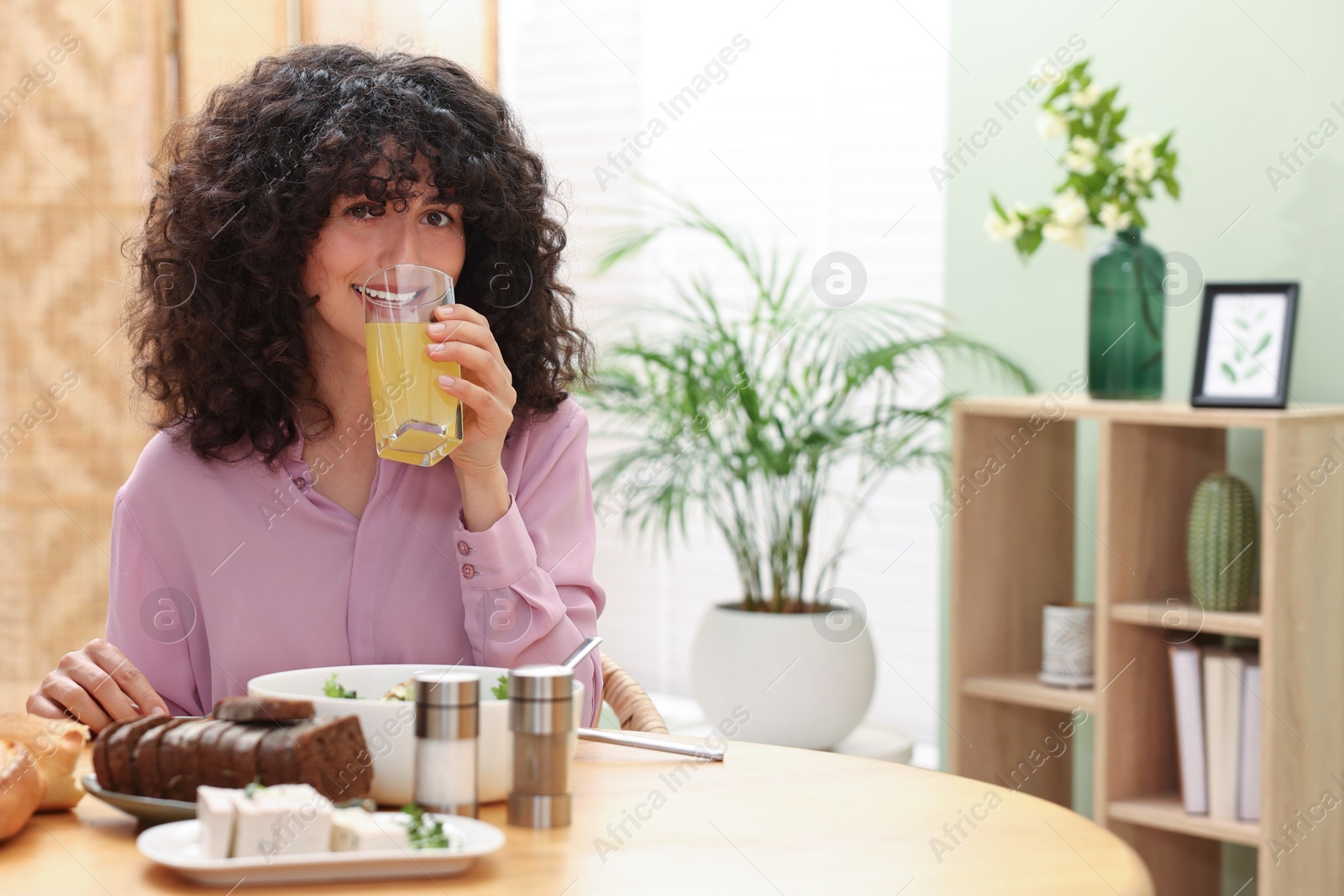 Photo of Woman having vegetarian meal at table in cafe