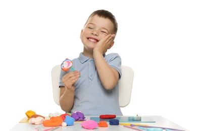 Photo of Smiling boy with play dough handiwork at table on white background
