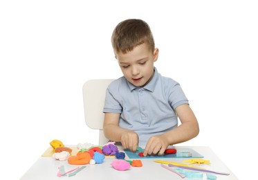 Photo of Little boy sculpting with play dough at table on white background