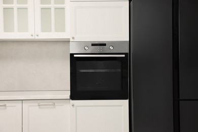 Photo of New electric oven in kitchen. Cooking appliance