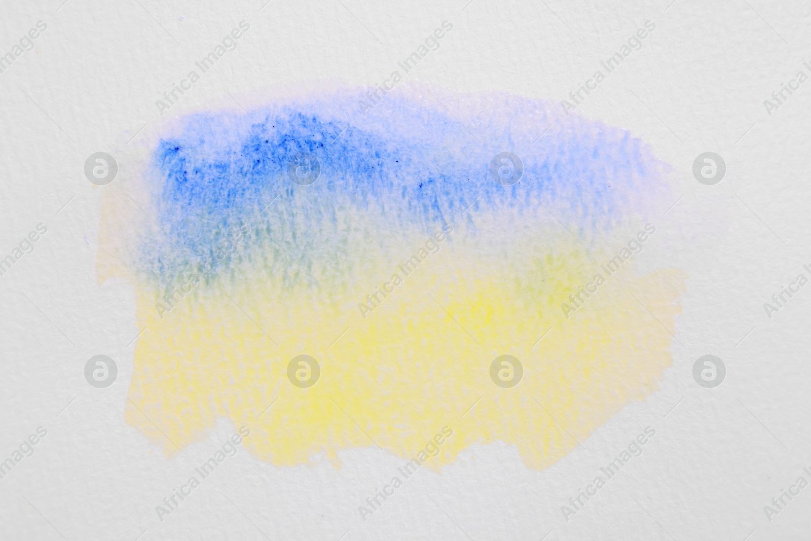 Photo of Blot of bright watercolor paints on white paper, top view