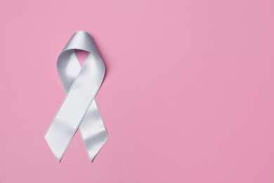 Photo of International Psoriasis Day. Light blue ribbon as symbol of support on pink background, top view. Space for text