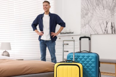 Guest exploring stylish hotel room, focus on suitcases
