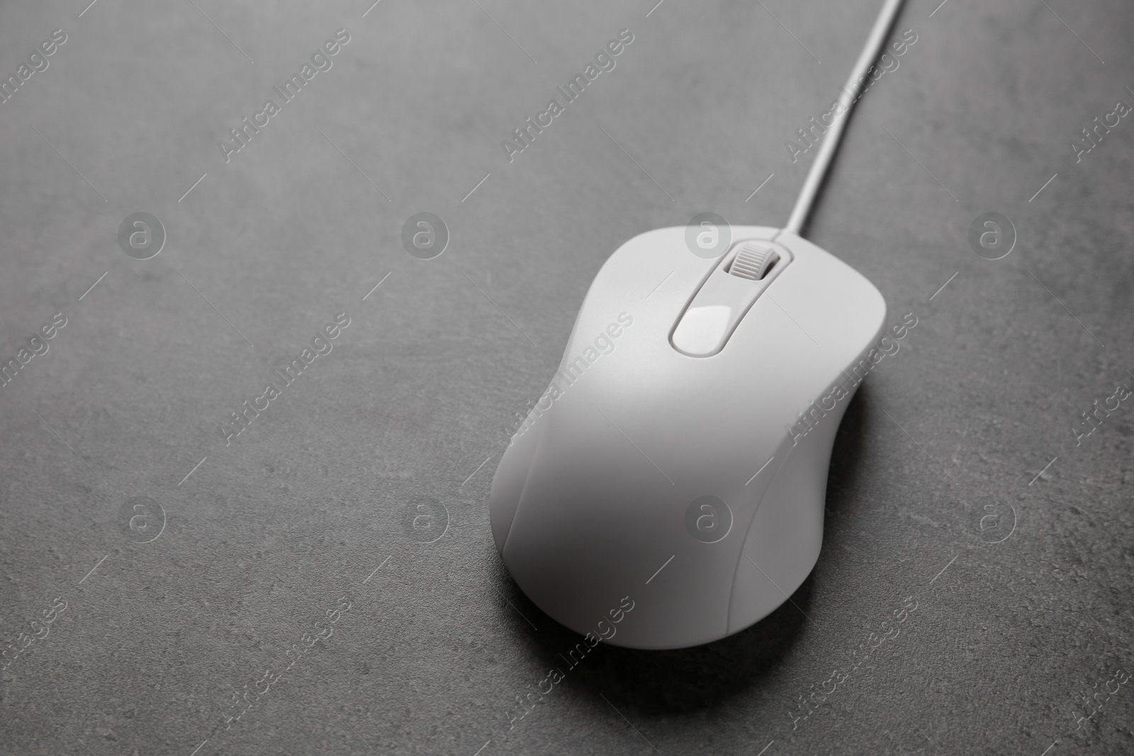 Photo of One wired mouse on black textured table, closeup. Space for text