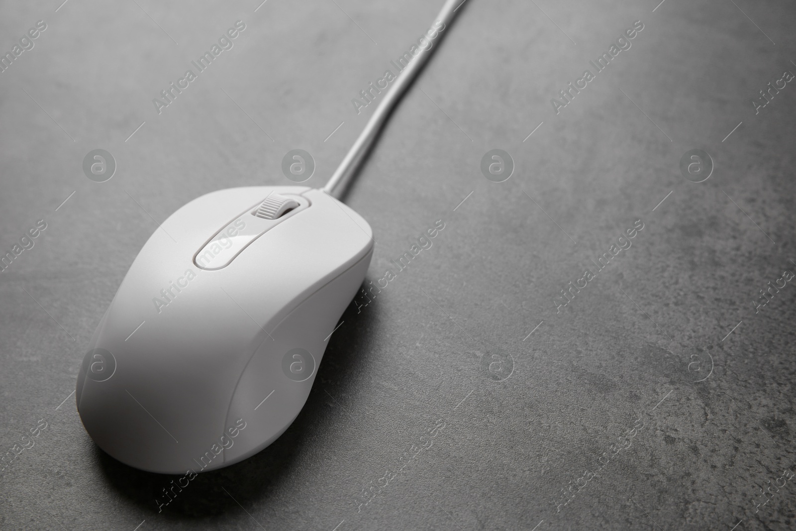 Photo of One wired mouse on black textured table, closeup. Space for text