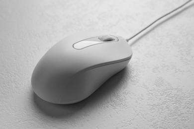 Photo of One wired mouse on light textured table, closeup