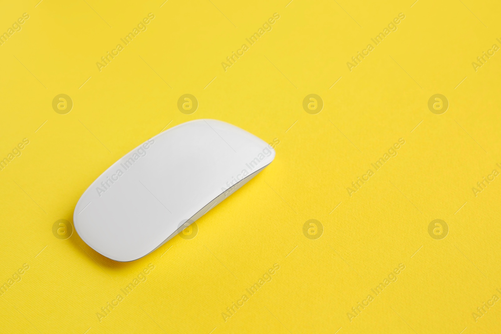 Photo of One wireless mouse on yellow background. Space for text