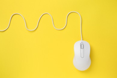 Photo of One wired mouse on yellow background, top view. Space for text