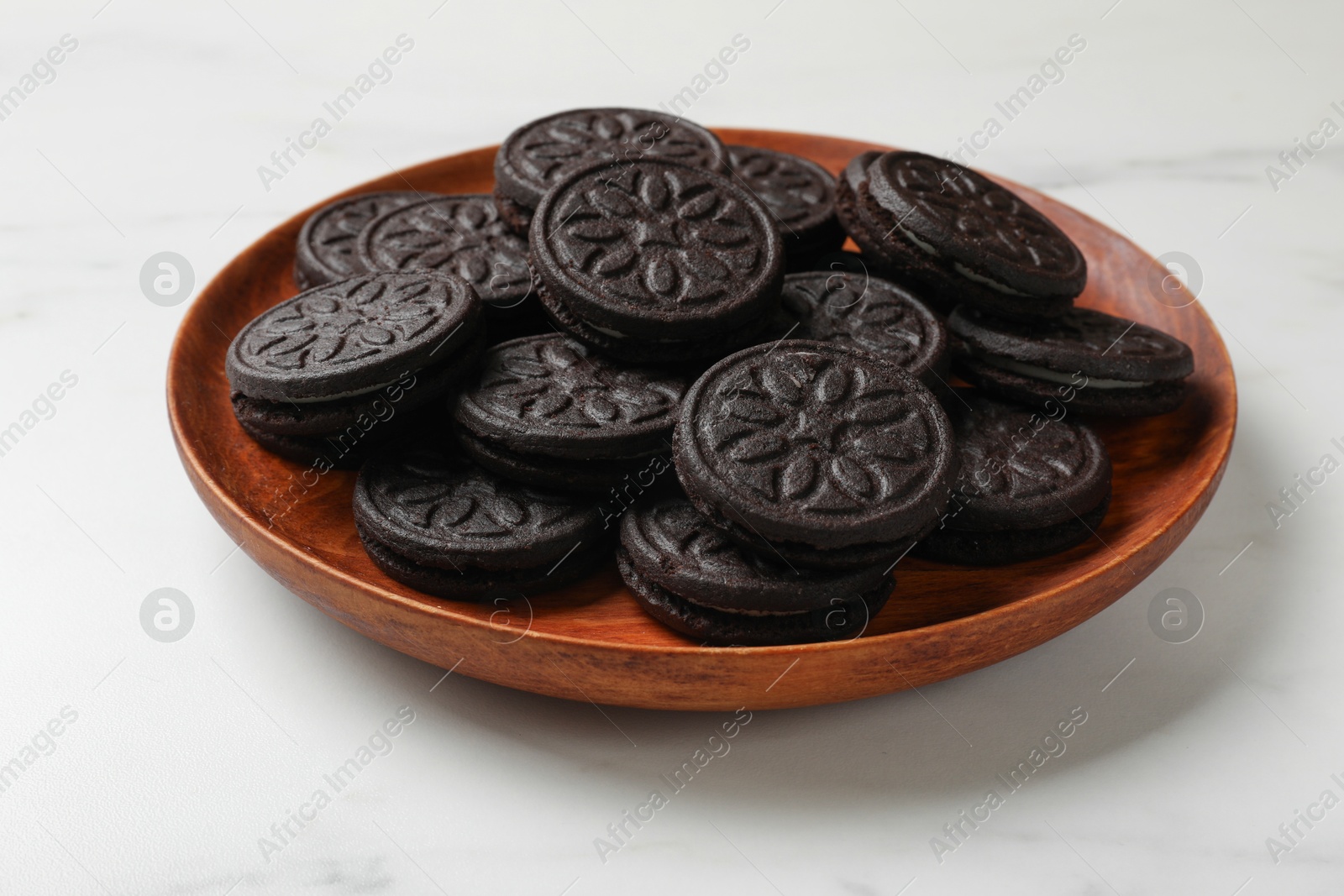 Photo of Plate with tasty sandwich cookies on white table, closeup