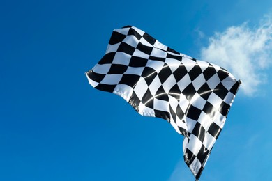 Checkered flag against blue sky outdoors, low angle view. Space for text