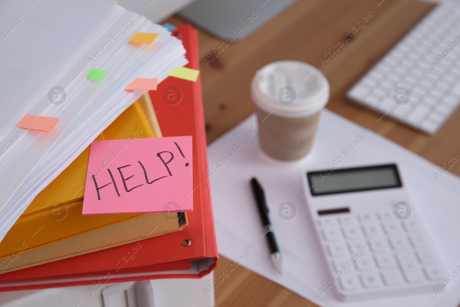 Photo of Note with word Help and stationery on wooden table at workplace, closeup