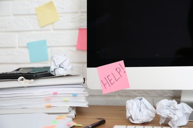 Photo of Note with word Help and stationery on computer at workplace