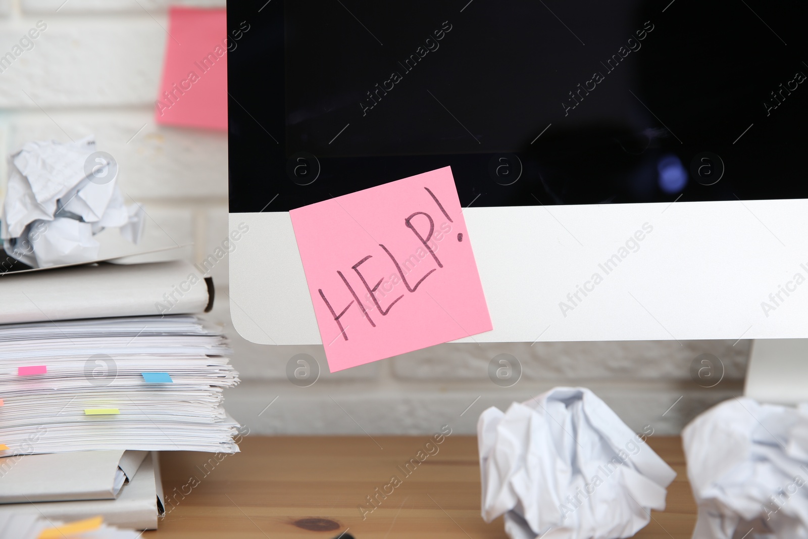 Photo of Note with word Help and stationery on computer at workplace