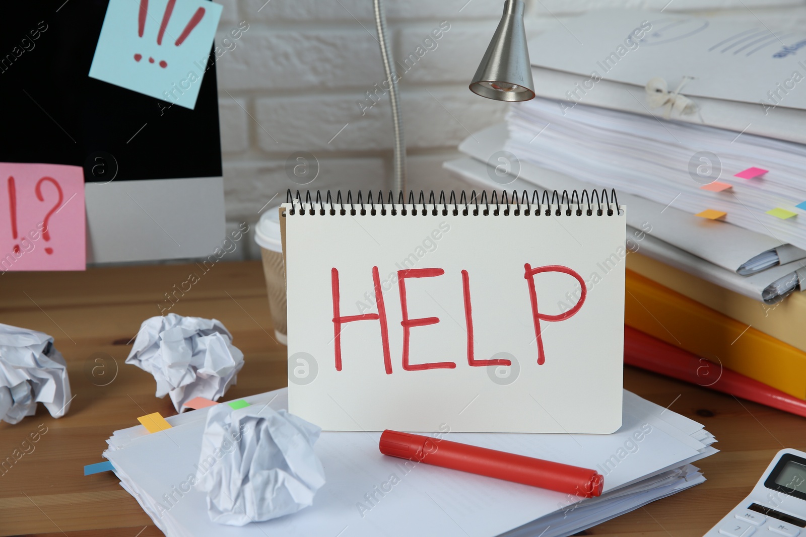 Photo of Notebook with word Help, computer and stationery on wooden table at workplace