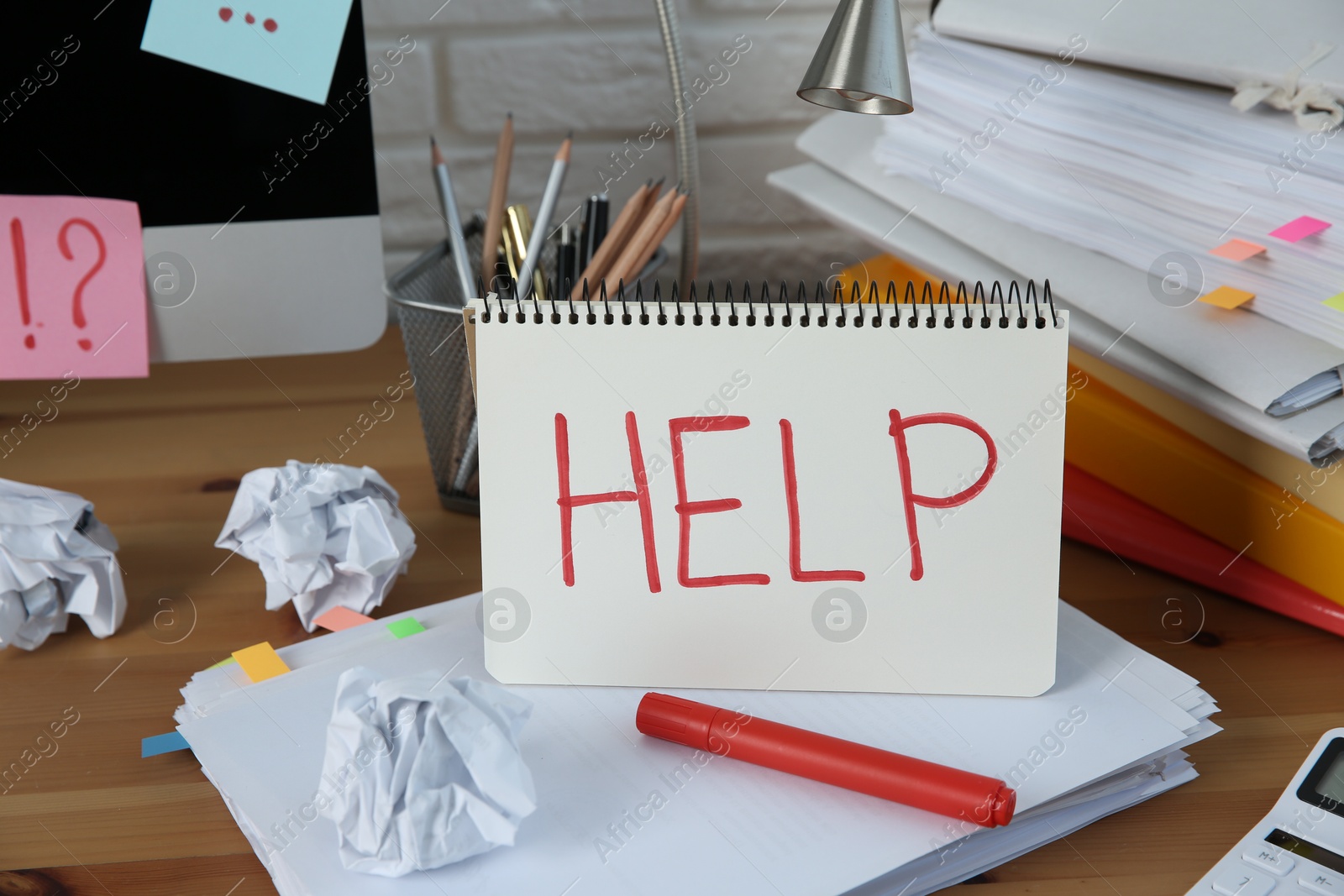 Photo of Notebook with word Help, computer and stationery on wooden table at workplace