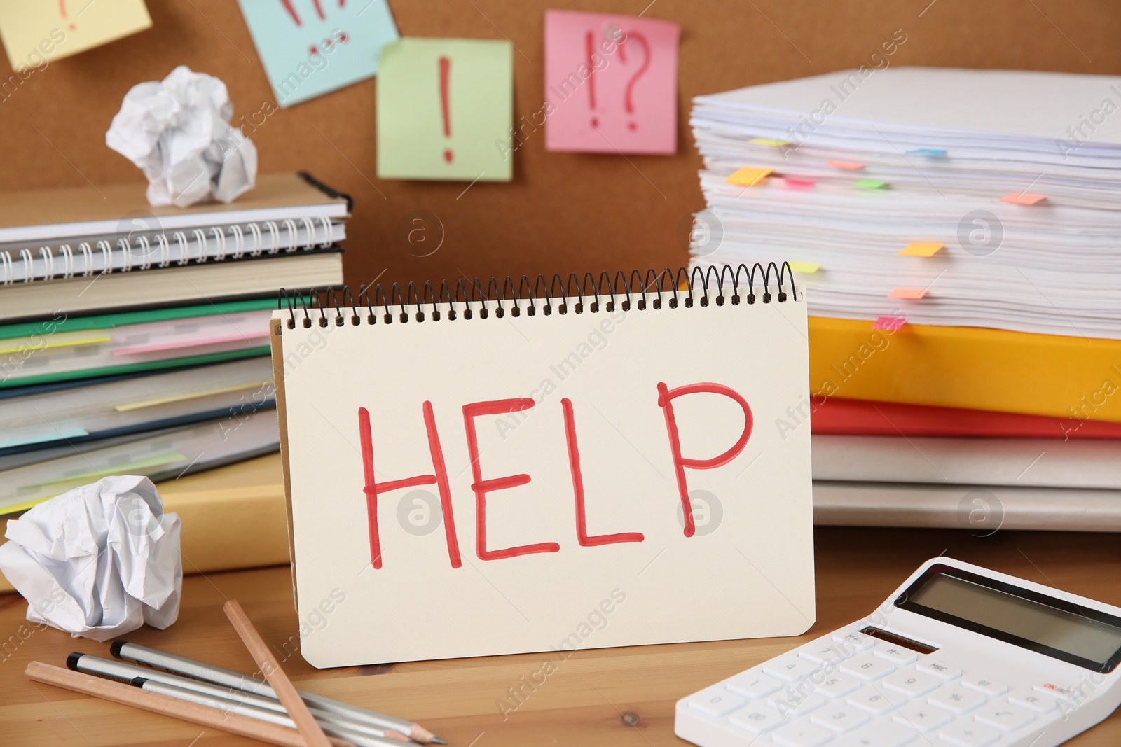 Photo of Notebook with word Help and stationery on wooden table at workplace