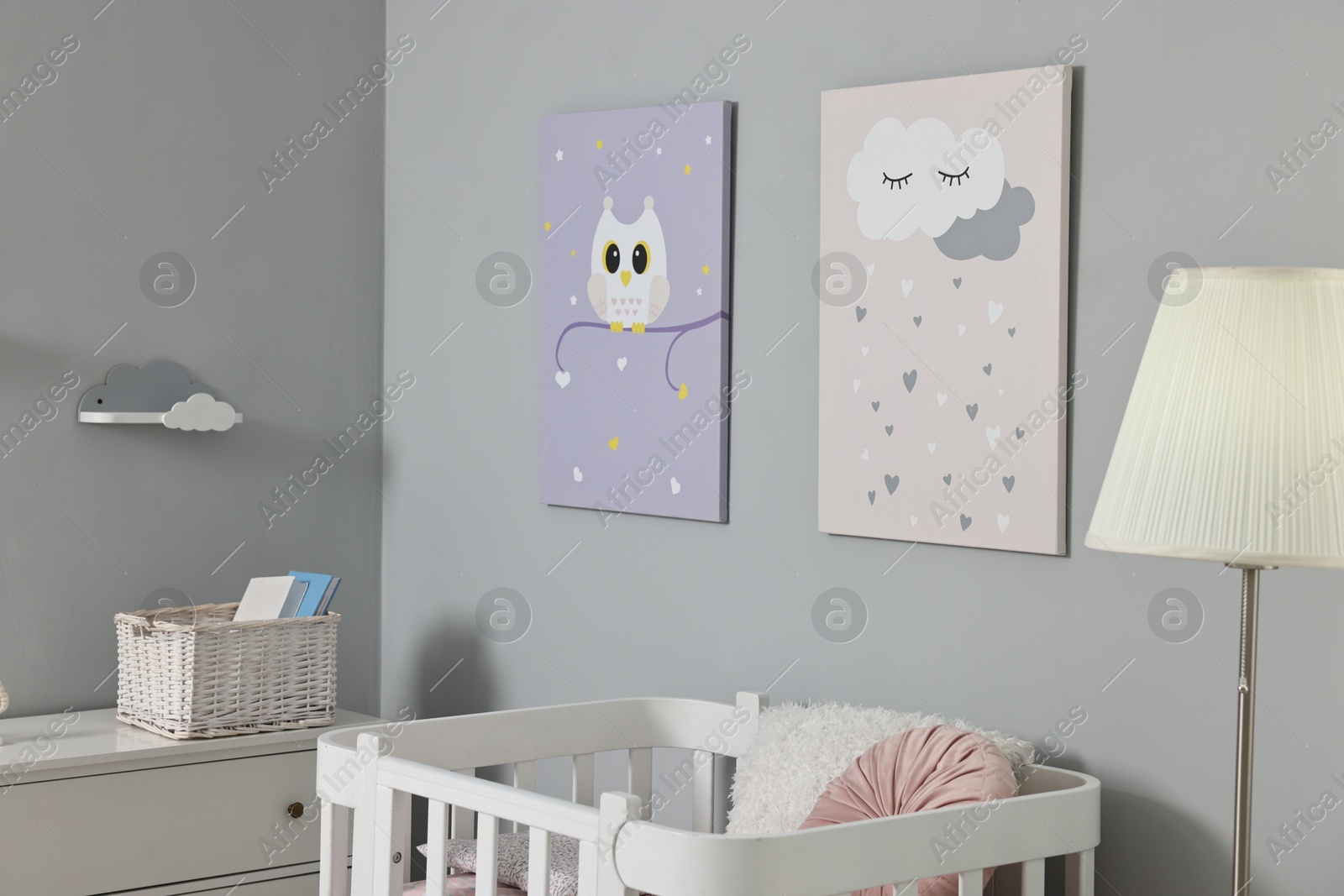 Photo of Newborn baby room interior with stylish furniture, comfortable crib and pictures of on wall