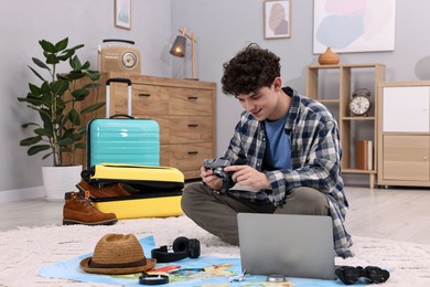 Photo of Travel blogger with vintage camera and other items for trip at home